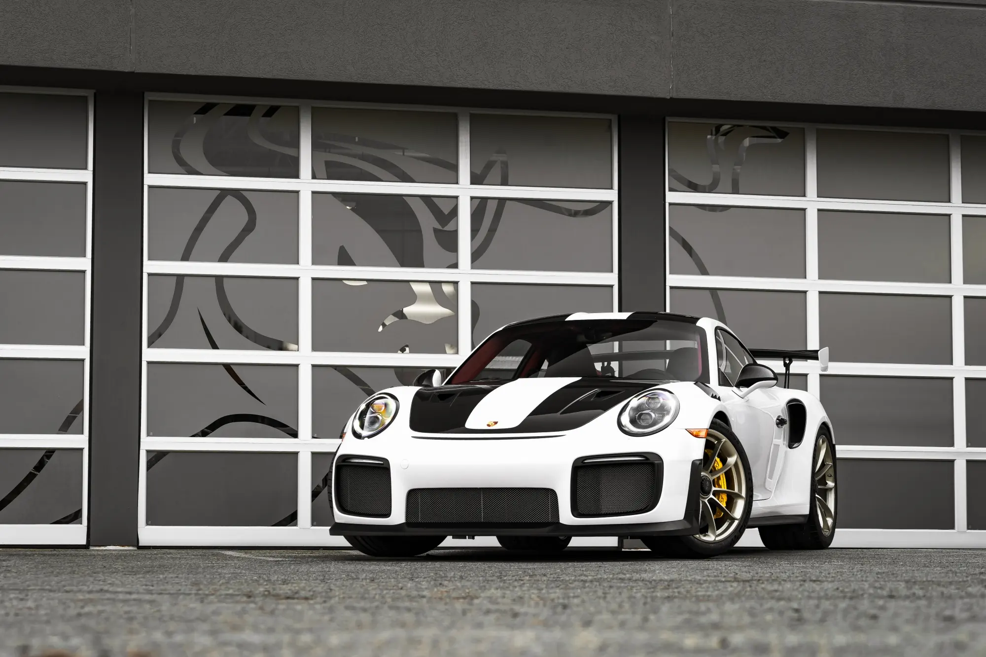White Porsche 911 GT2 RS in front of the glass bay doors at Moppert Auto Collision in Ogletown, DE