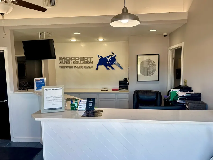 Front desk at Moppert Auto Collision in Turnersville with the Moppert bull logo on the wall