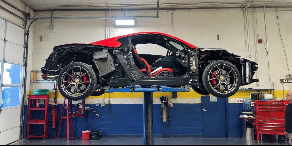 Ferrari with its front and rear bumpers removed, raised on a lift in the Turnersville repair bay